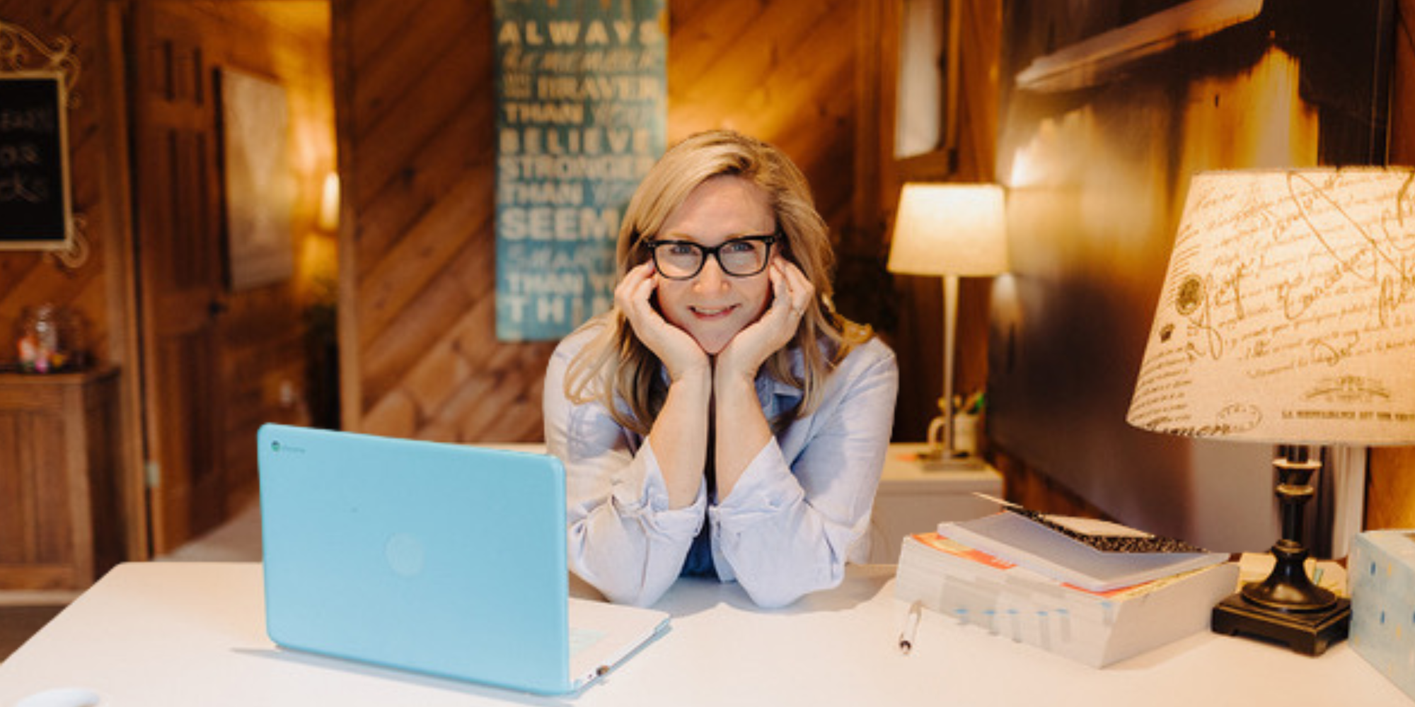 Teresa Lubovich, owner of Bright Heart Learning in Poulsbo, smiling at her desk with a laptop in her warm, wood-paneled office